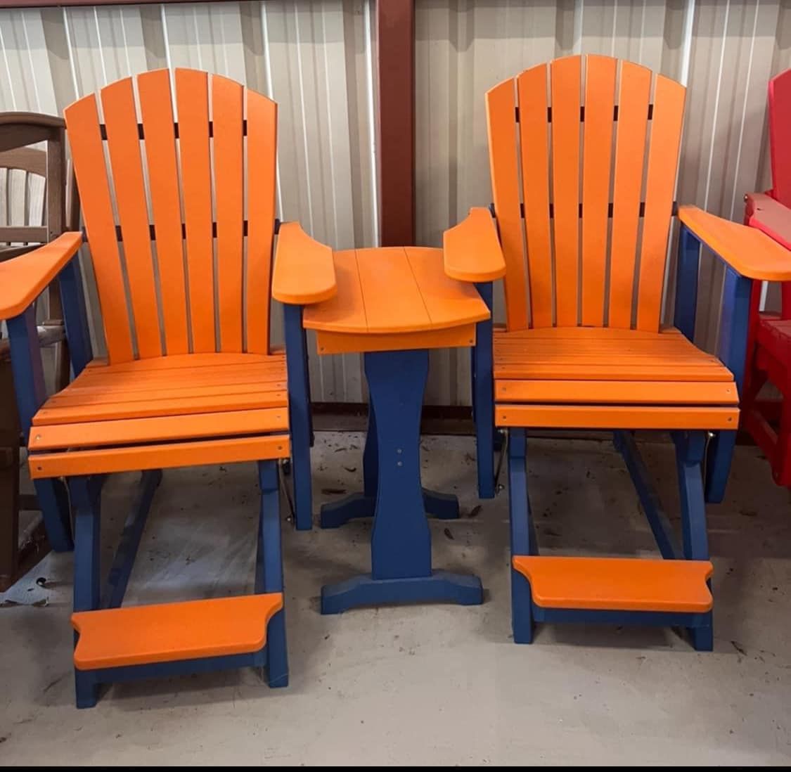 Two orange and blue chairs with a small table between them