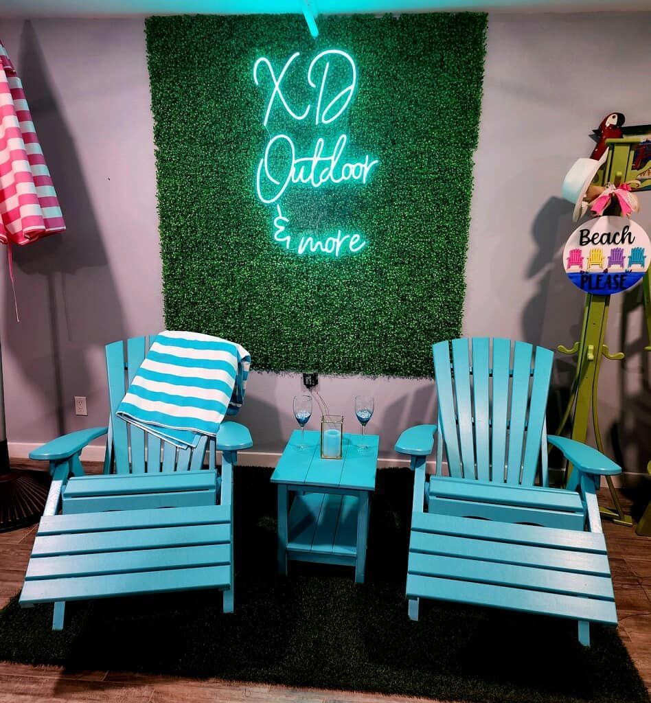 Two blue chairs are sitting in front of a neon sign that says `` xd outdoor and more ''.