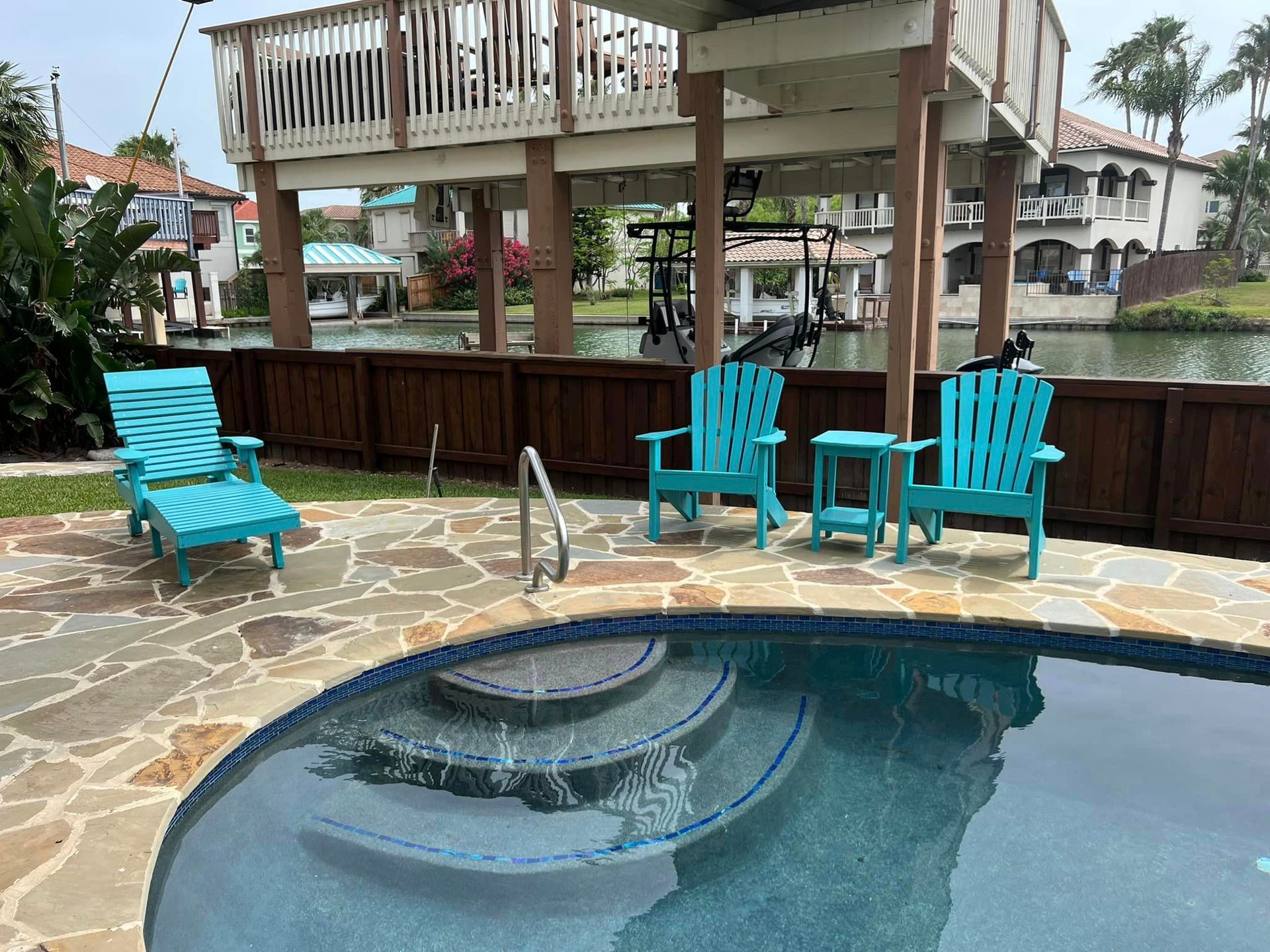 A swimming pool with chairs and tables around it