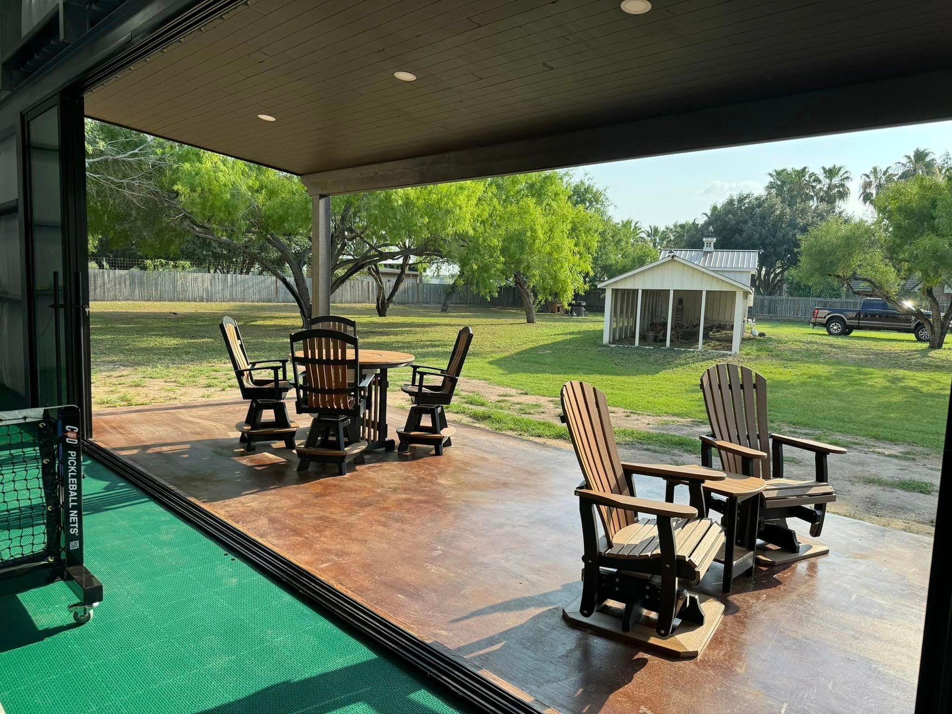 A patio with a table and chairs and a sliding glass door.