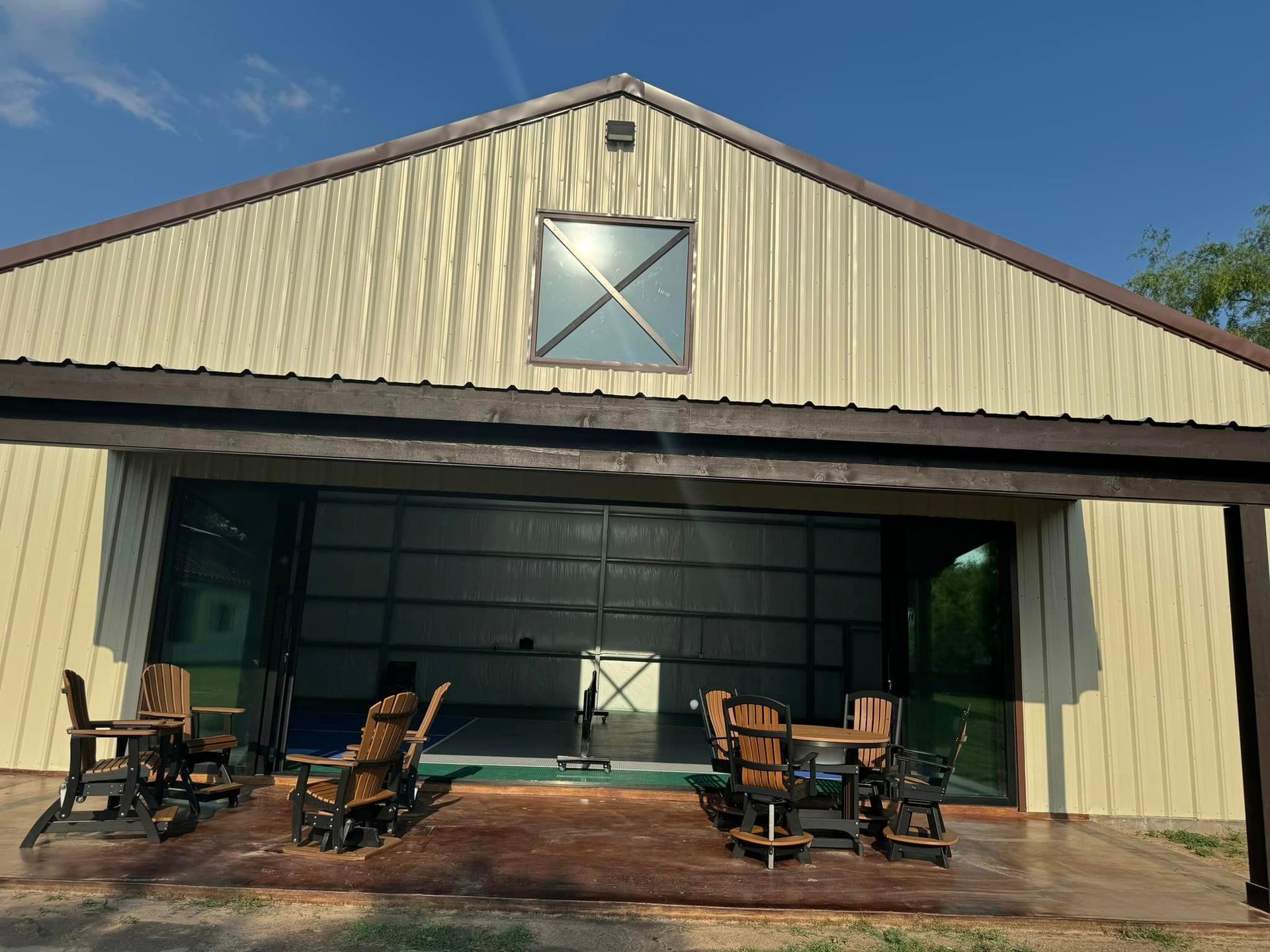 A large building with a sliding glass door and chairs in front of it.