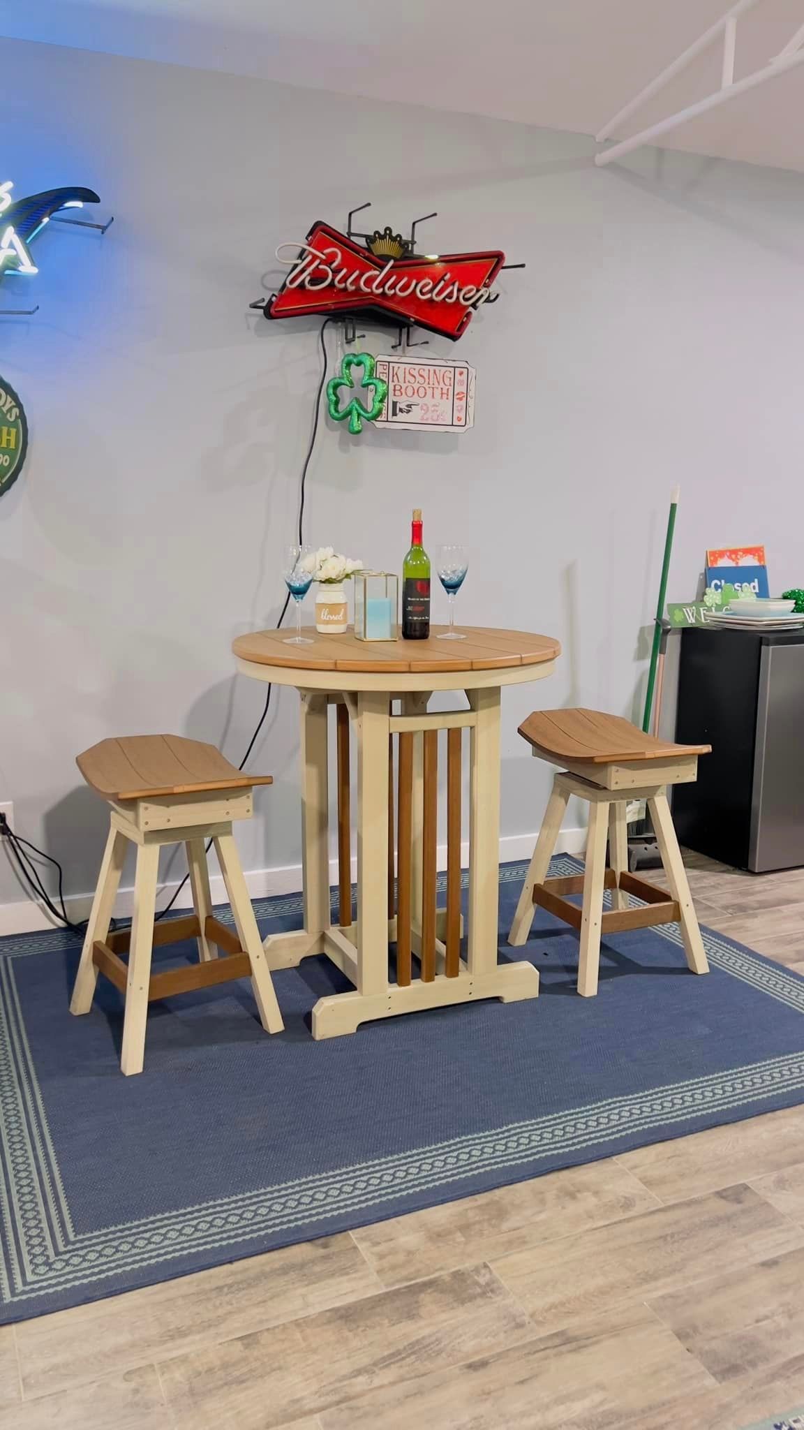 A table and stools in a room with a bottle of wine on it.