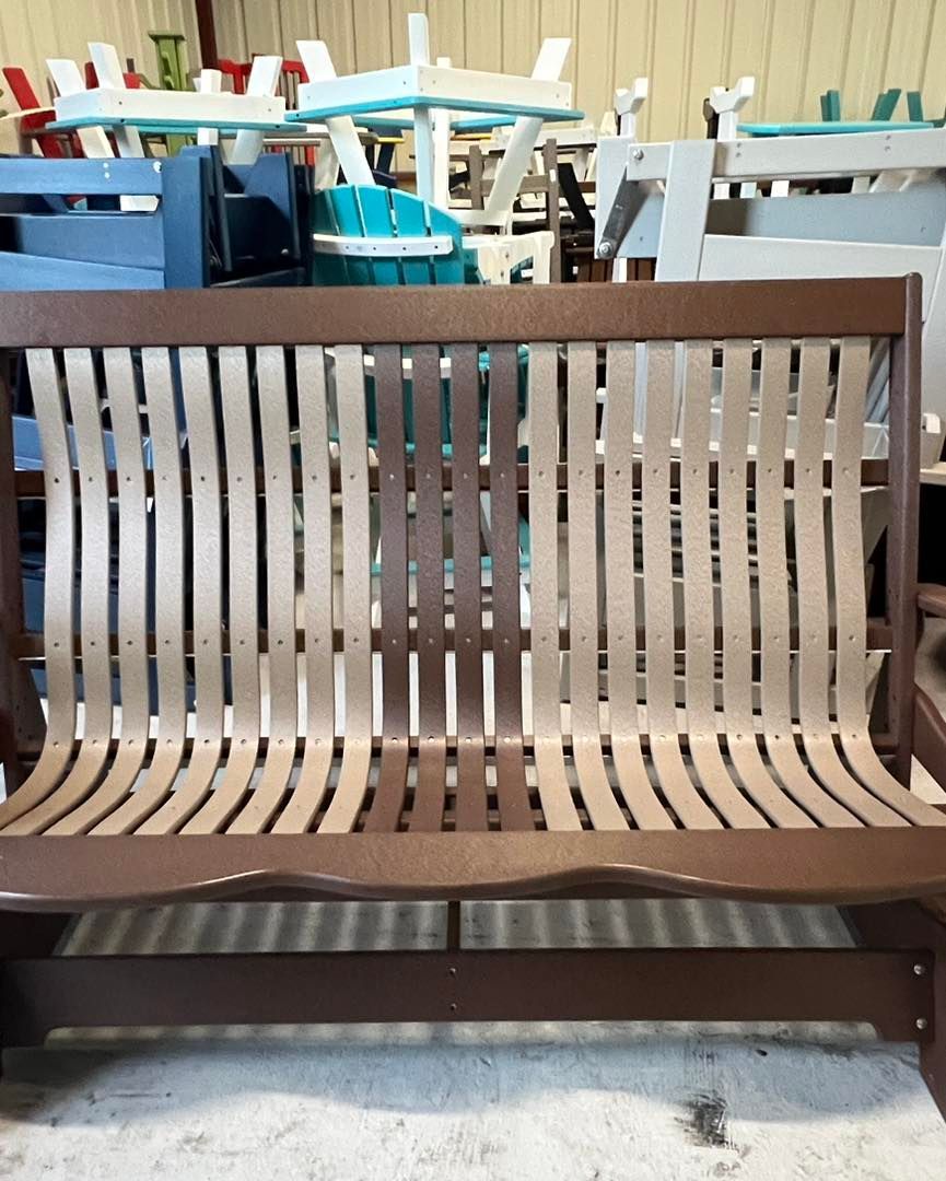 A wooden bench is sitting in front of a row of chairs