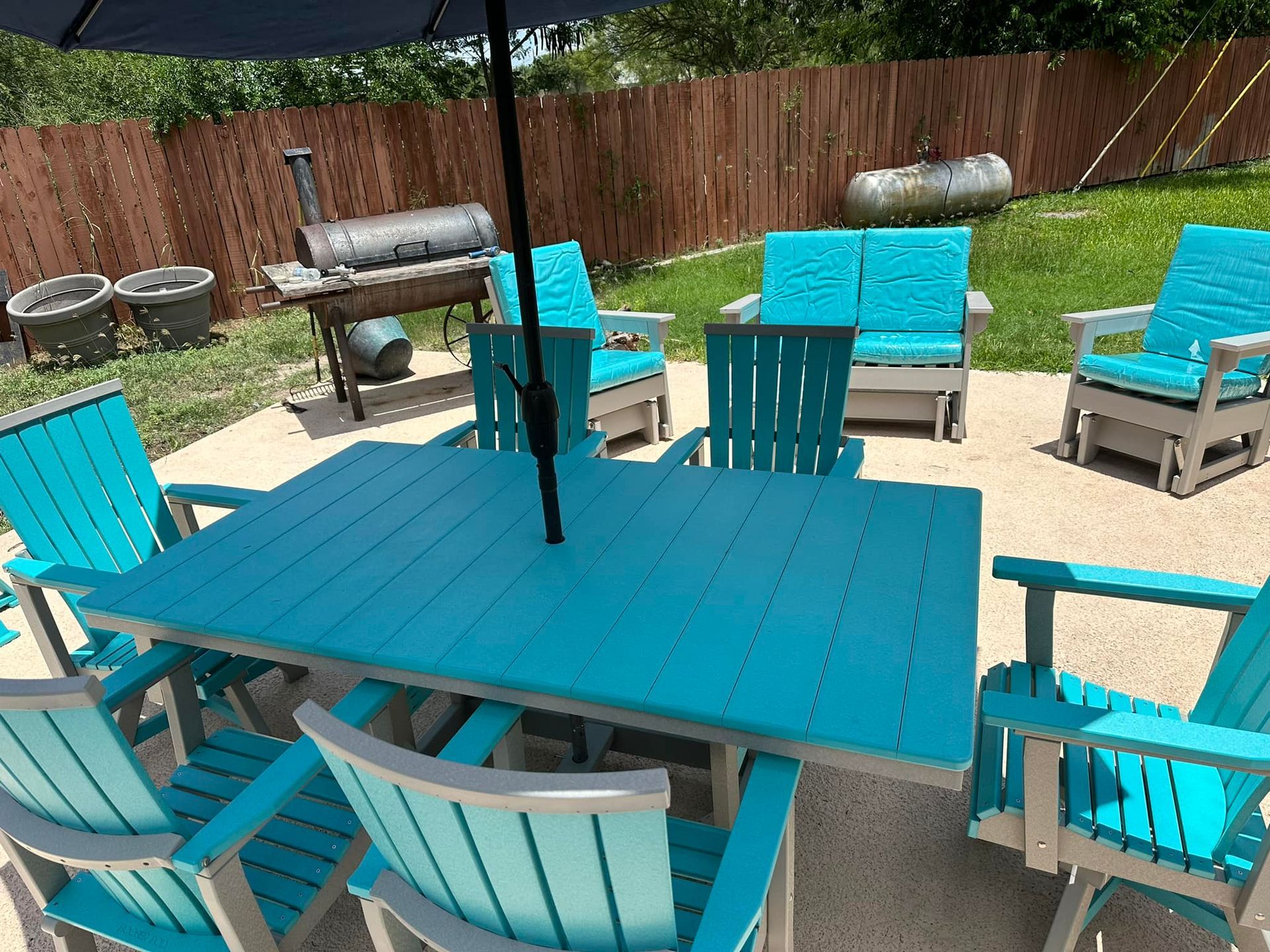 A patio with a table and chairs and an umbrella.