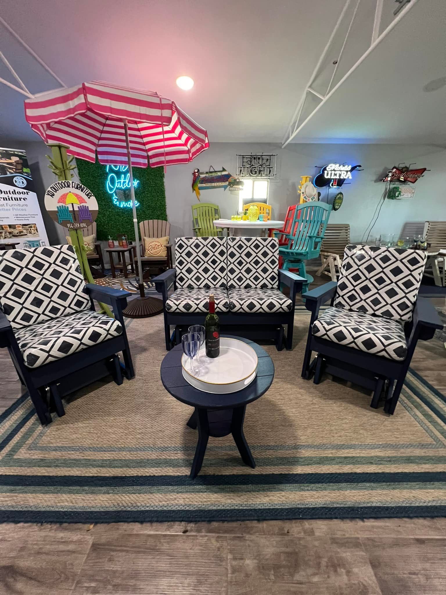 A living room with a couch , chairs , a table and an umbrella.