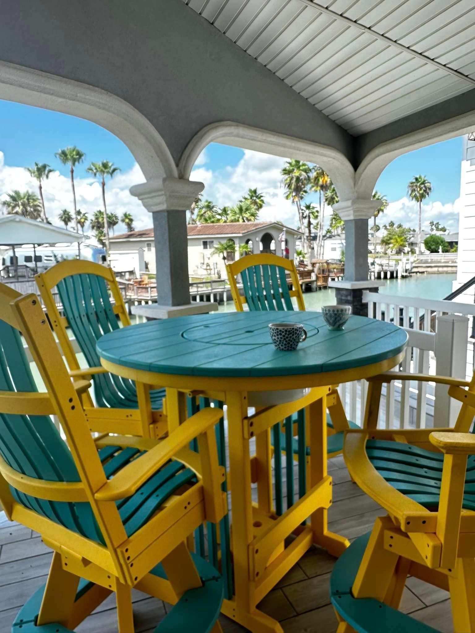 A table and chairs on a porch overlooking a body of water