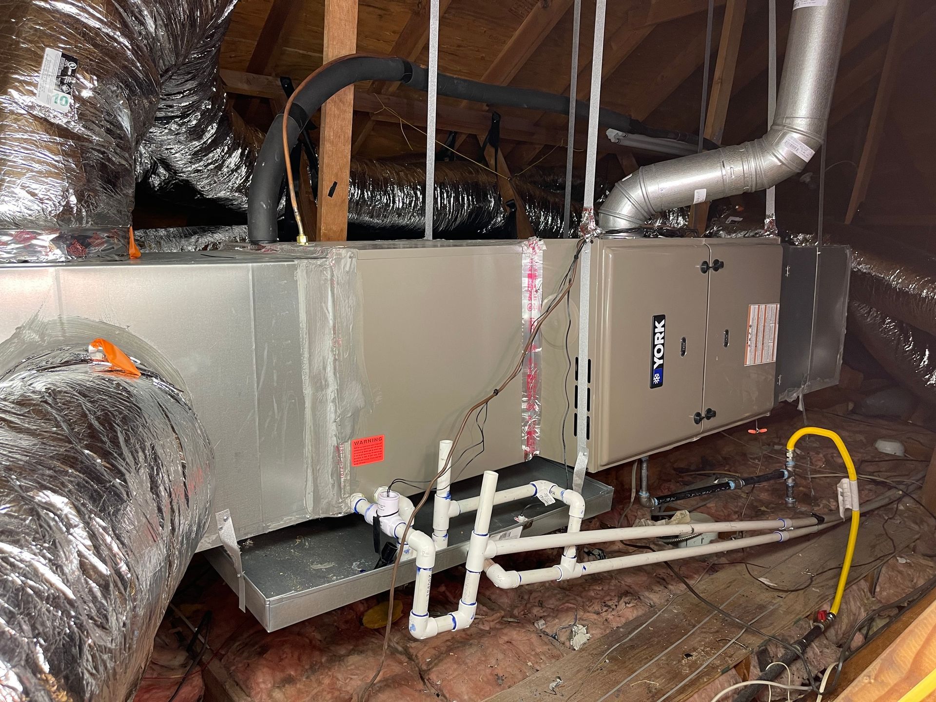 an air conditioner is installed in the attic of a house .