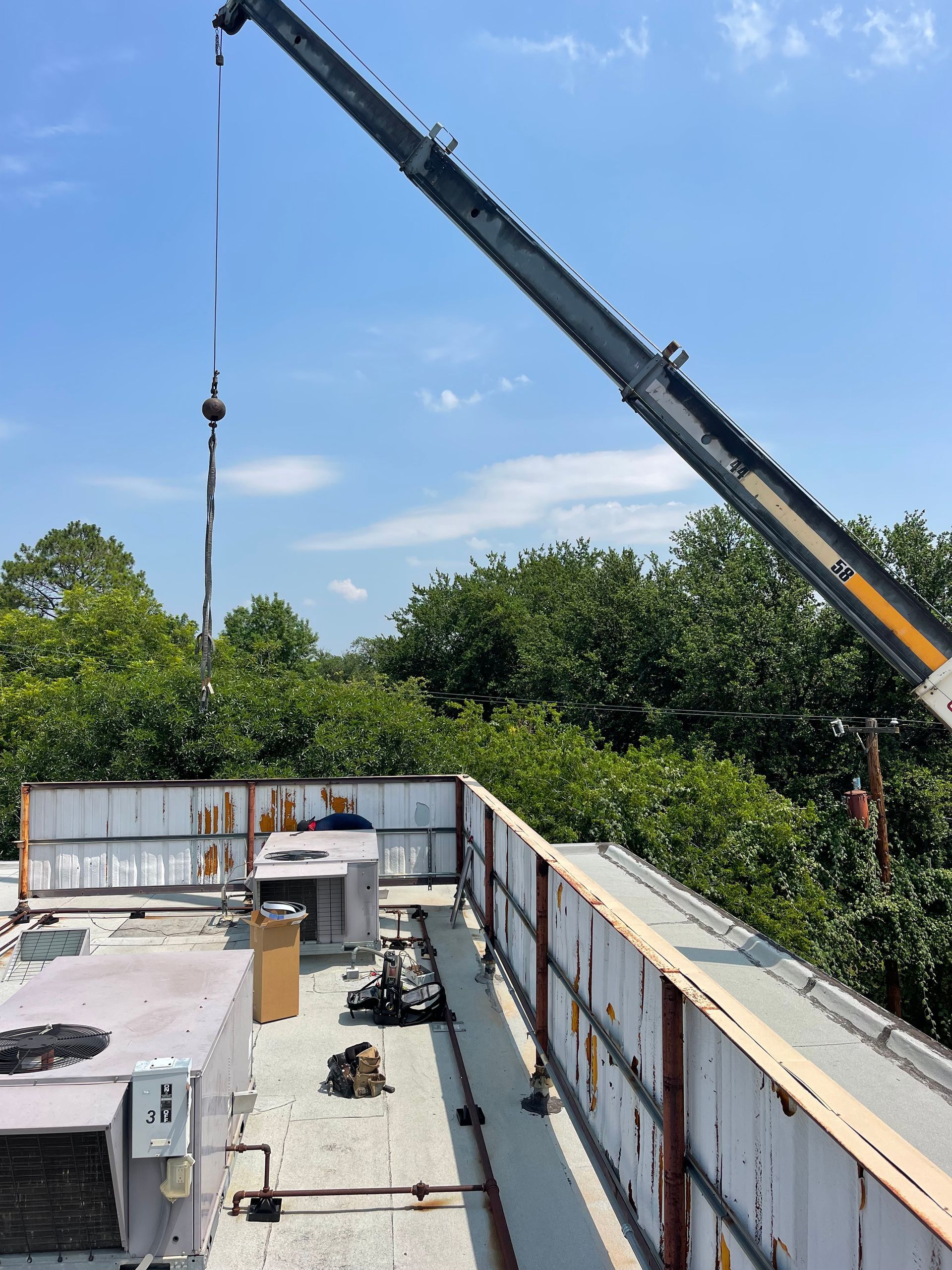 a crane is being used to lift a piece of metal on top of a building