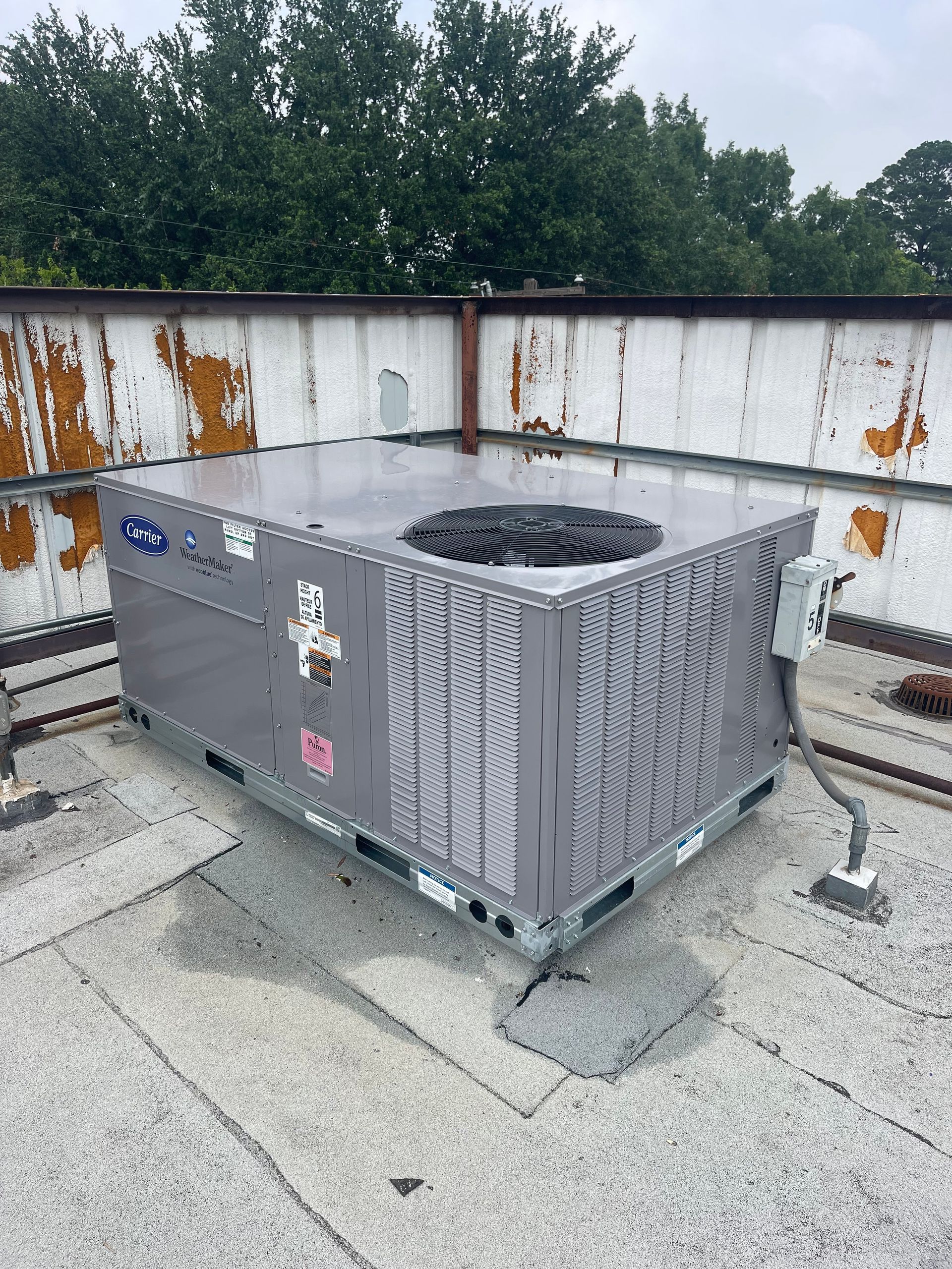 A large air conditioner is sitting on top of a roof.