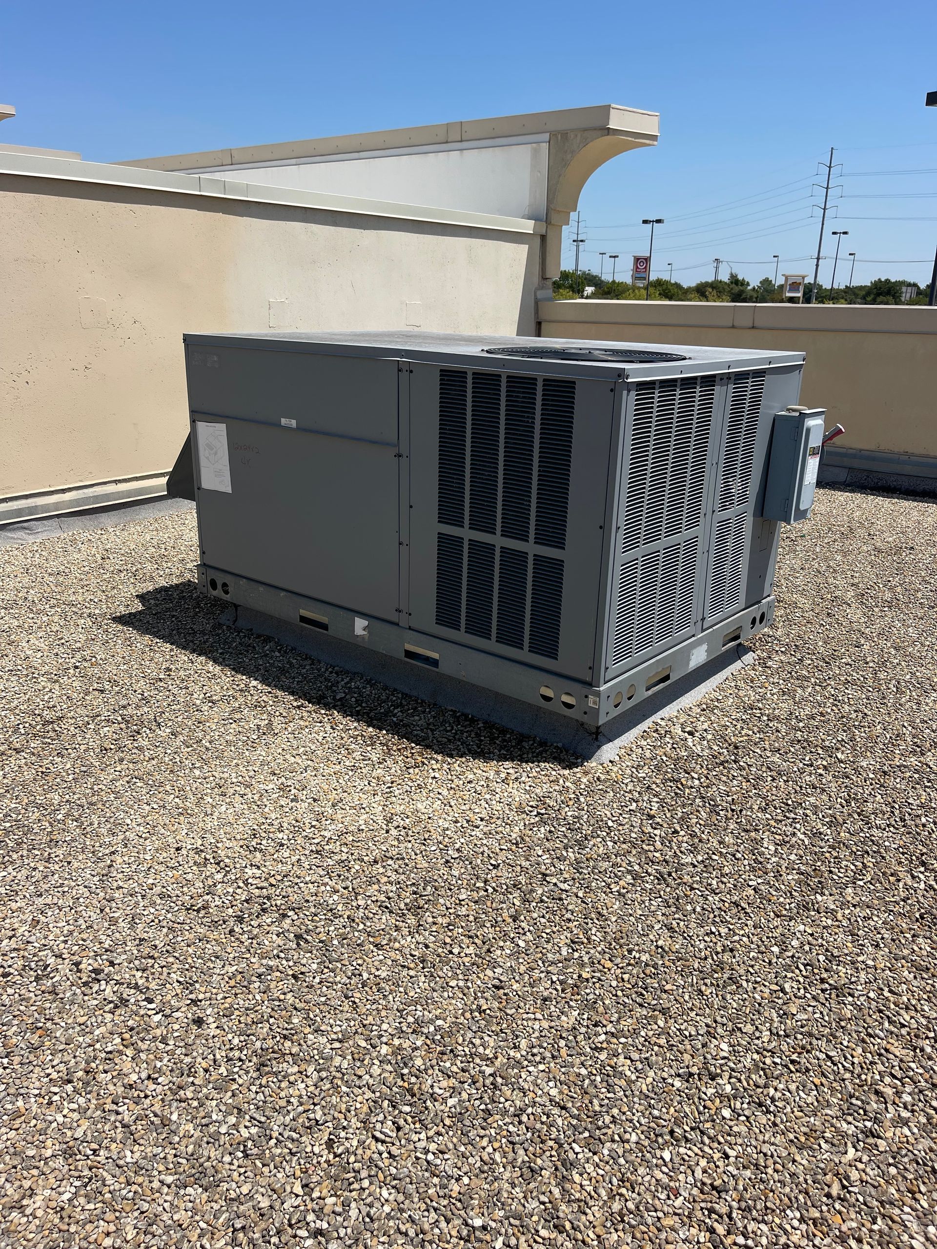 an air conditioner is sitting on top of a gravel covered roof .