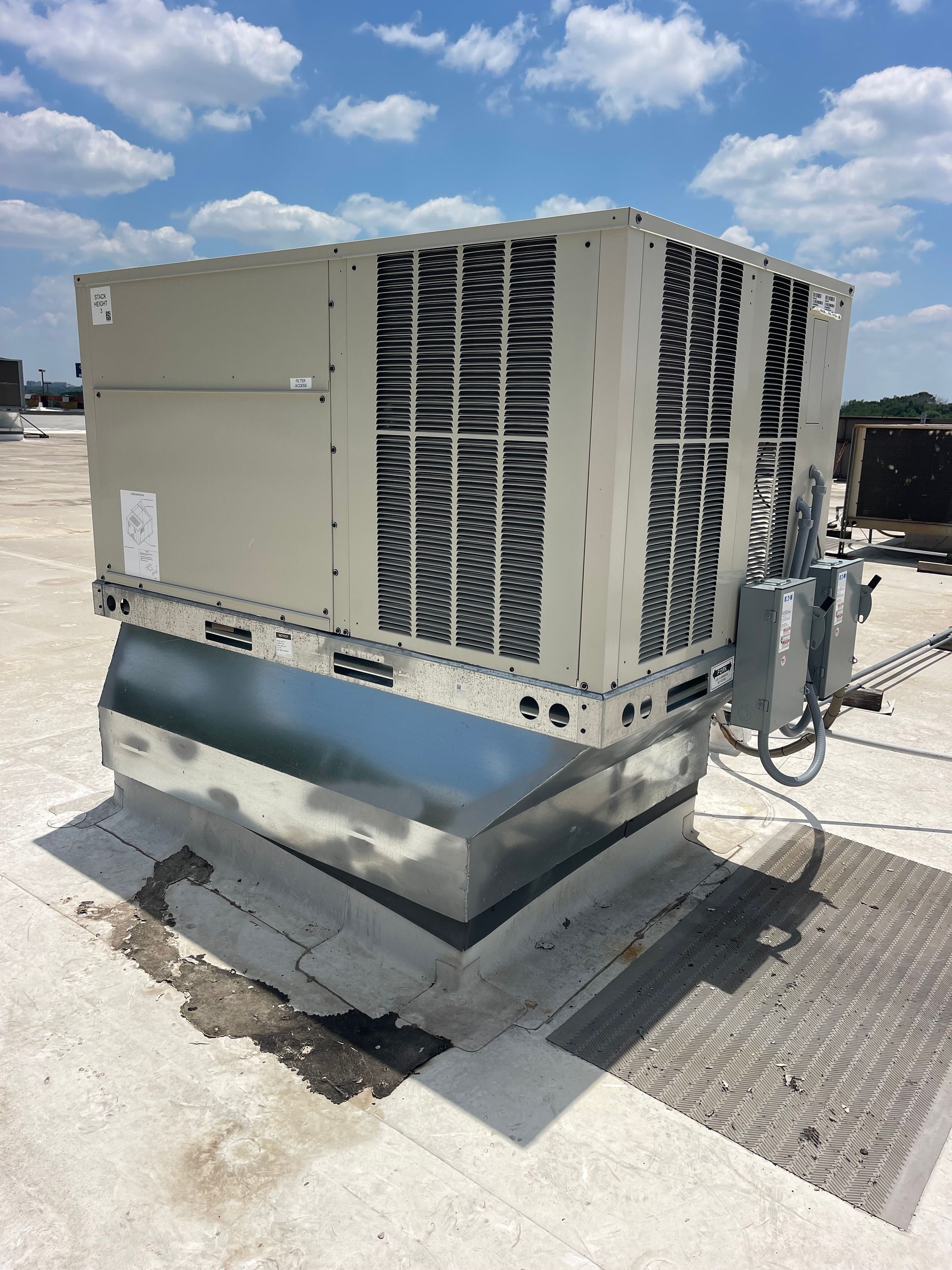 A large air conditioner is sitting on top of a roof