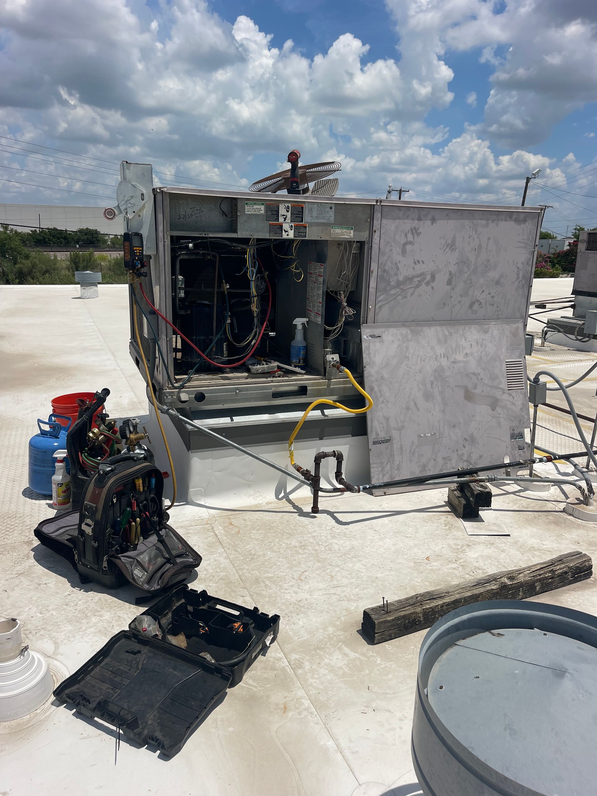 A broken air conditioner is sitting on top of a roof.