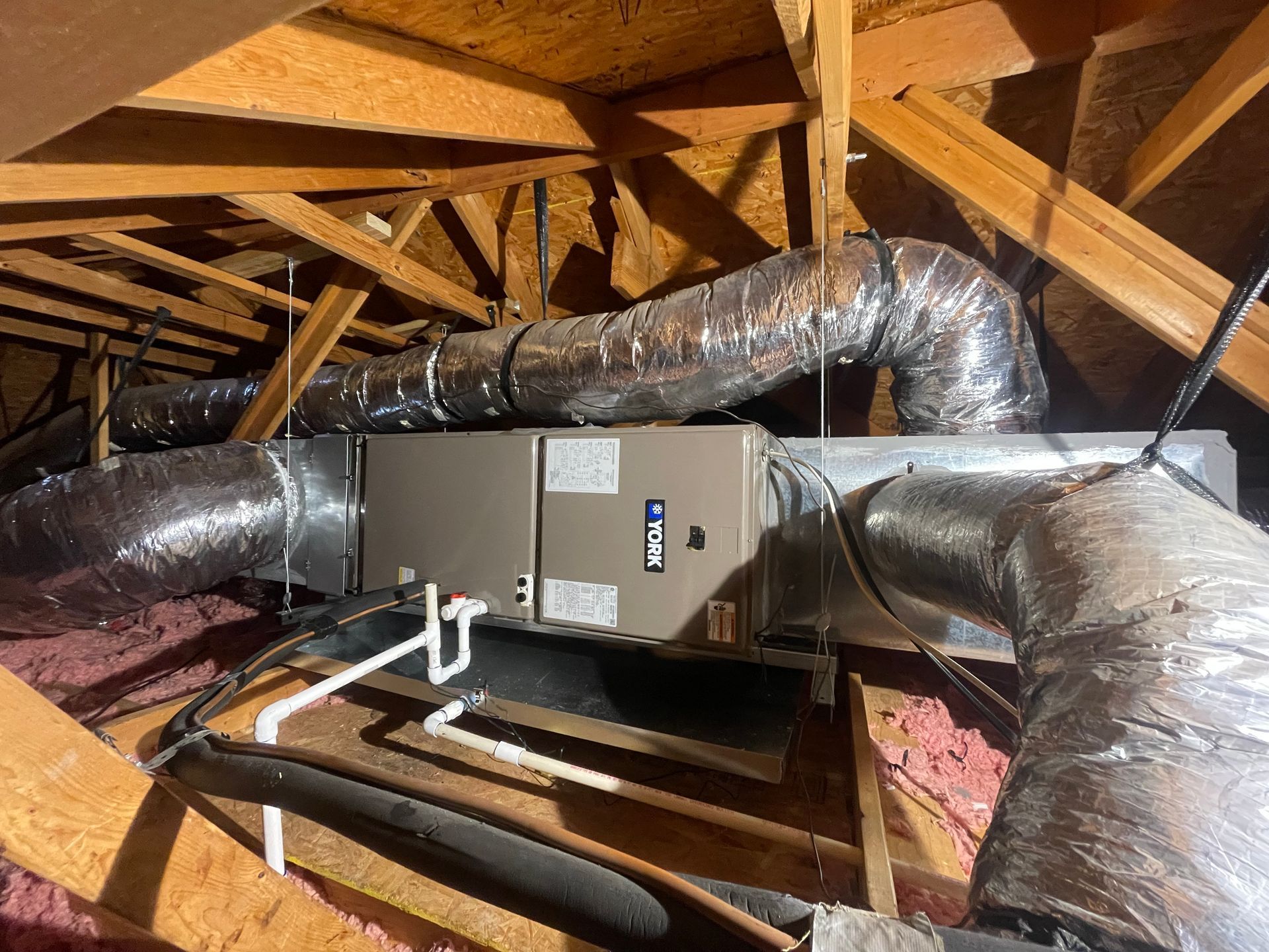An air conditioner is installed in the attic of a house.