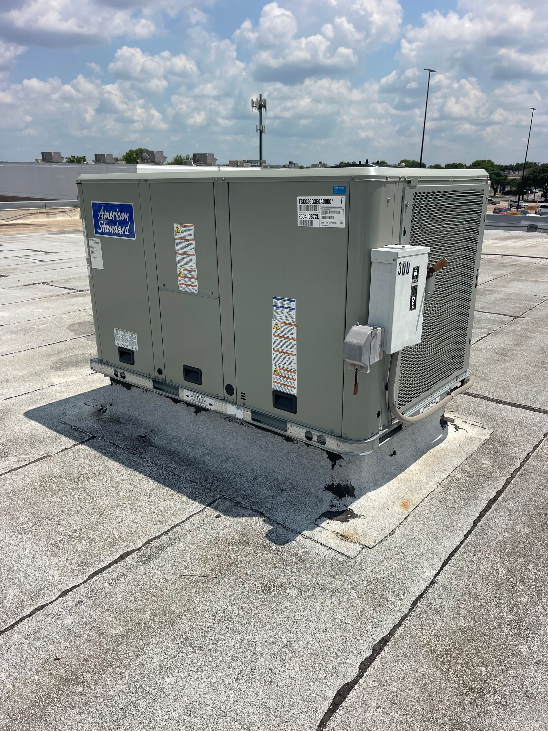 A large air conditioner is sitting on top of a roof.