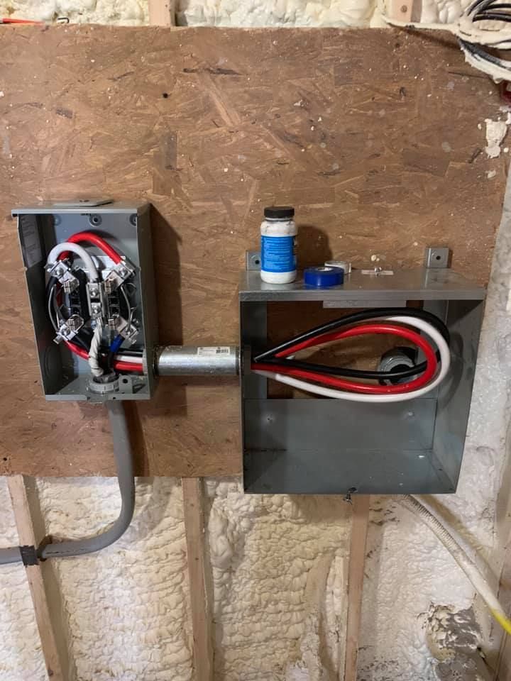 Electrical junction boxes with wires connected on a wooden wall.