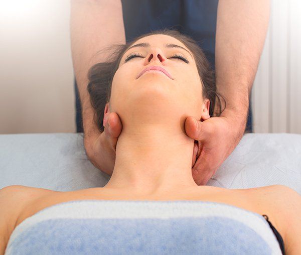 a woman is laying on a table getting a neck massage .