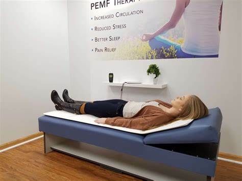 a woman is laying on a massage bed in a room.