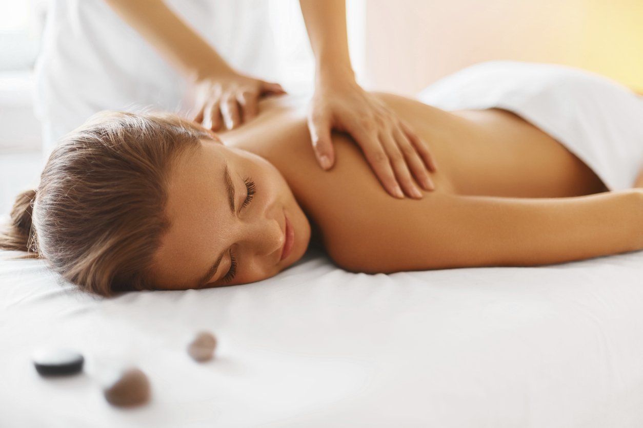 a woman is laying on a bed getting a massage .