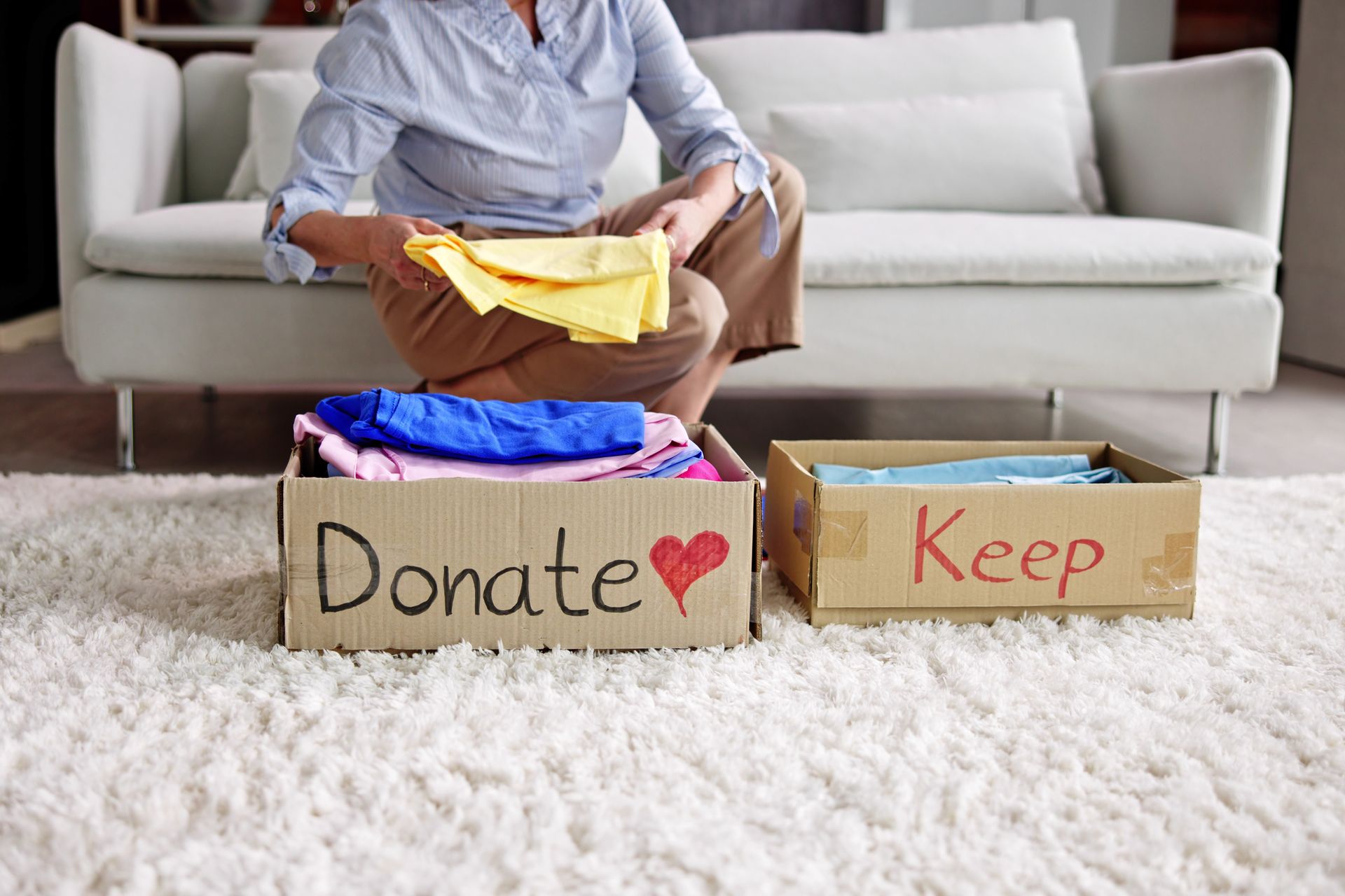 a cardboard box that says donate sits next to a cardboard box that says keep