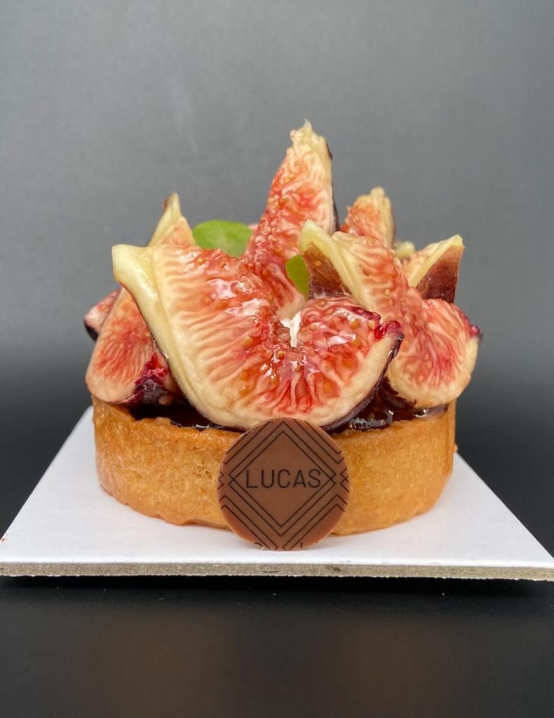 Tarte aux figues fraîches, surmontée d'un médaillon en chocolat sur lequel est écrit
