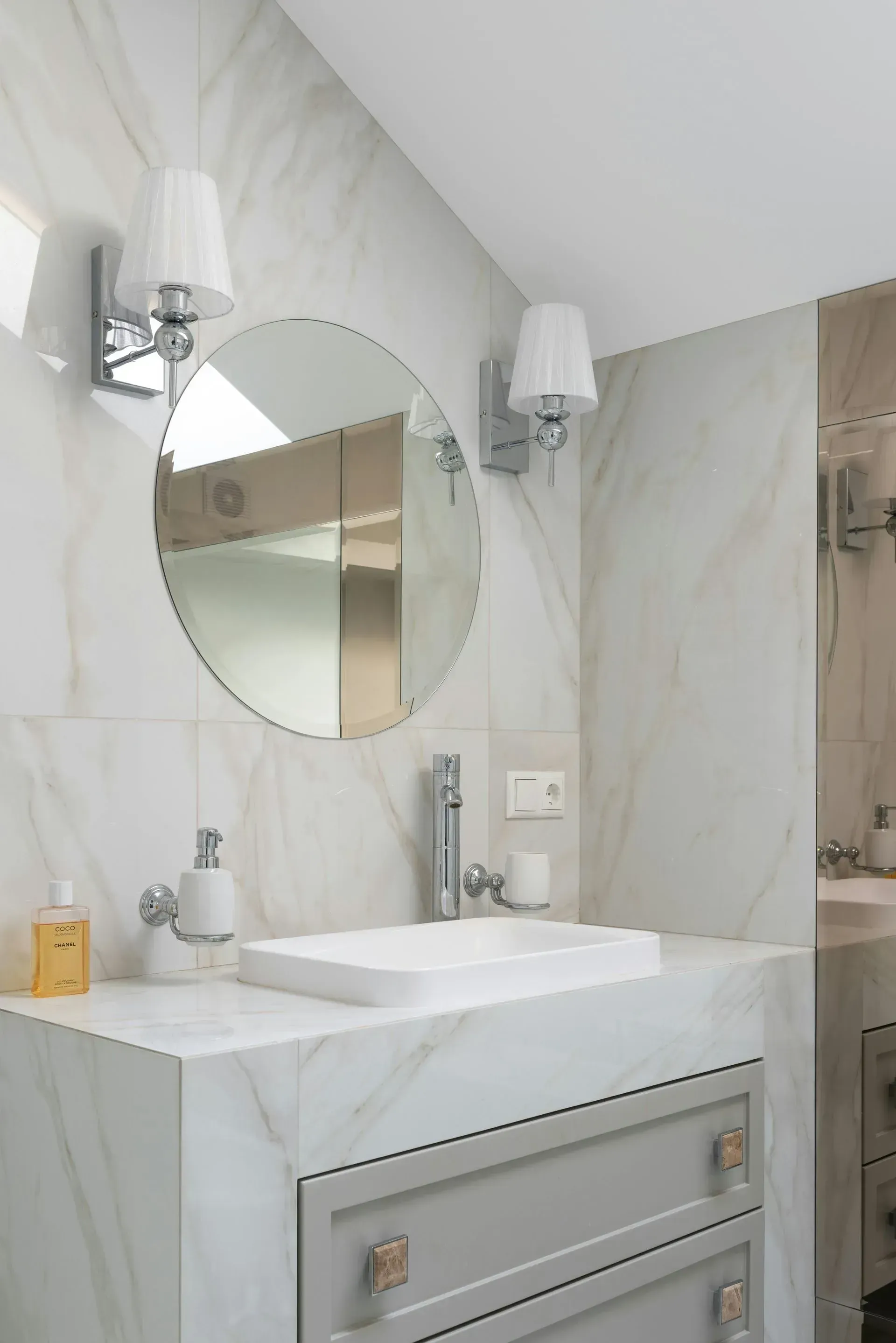 A bathroom with a sink and a round mirror in San Jose, CA