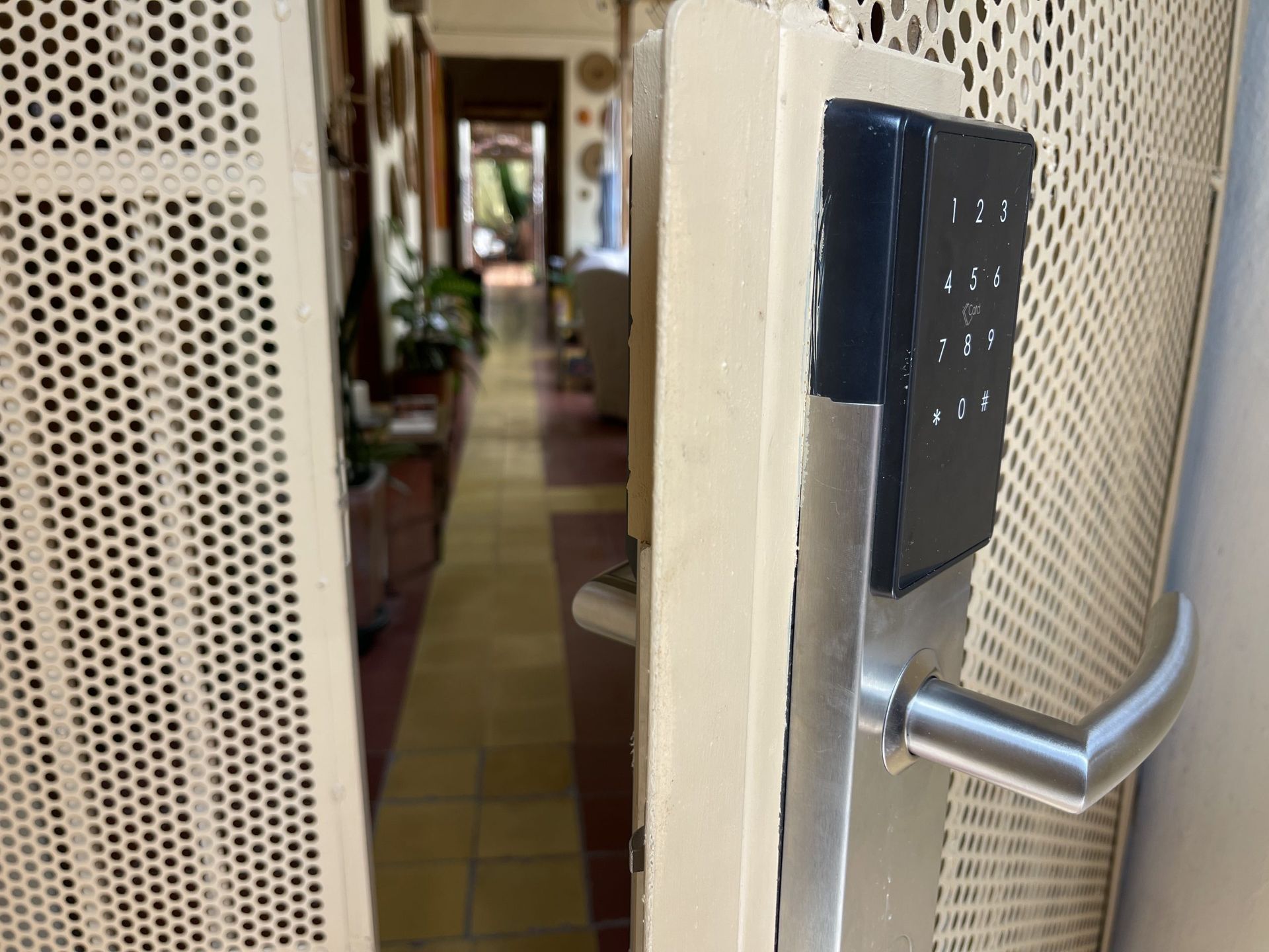 Una puerta con un teclado está abierta a un pasillo.