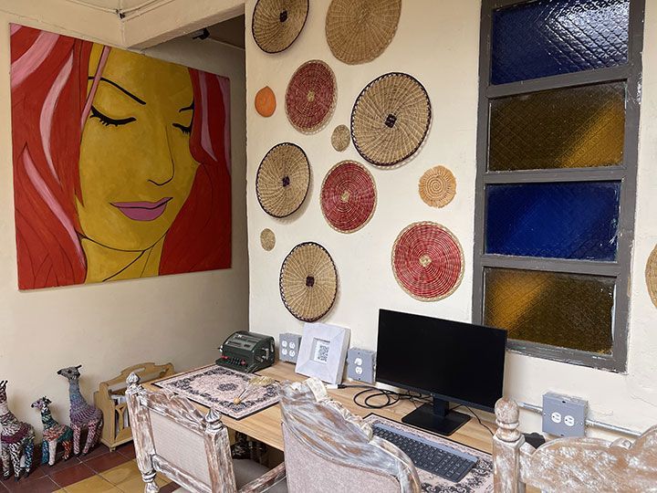 Una habitación con una computadora y un cuadro de una mujer en la pared.