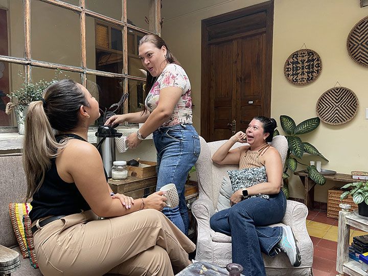 Tres mujeres están sentadas en un sofá en una sala de estar.