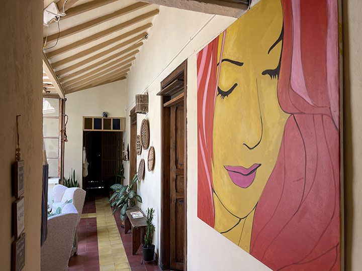 Un cuadro del rostro de una mujer está colgado en la pared de un pasillo.