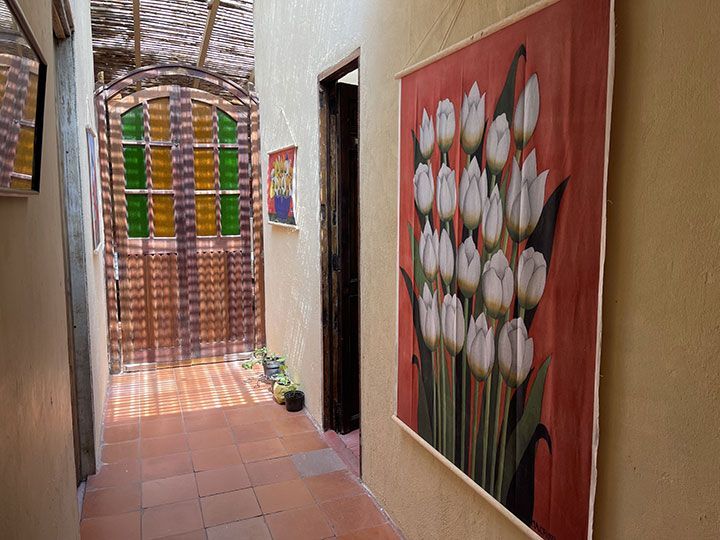 Un pasillo con un cuadro de flores en la pared.