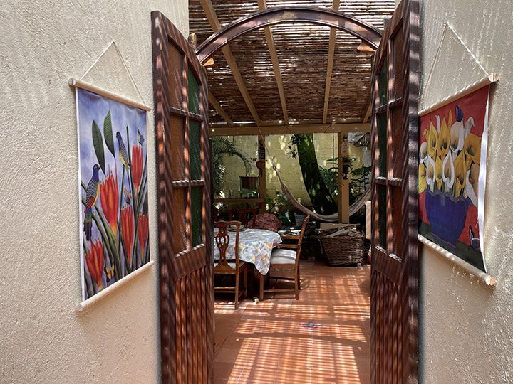 Un pasillo con una mesa y sillas y cuadros en la pared.