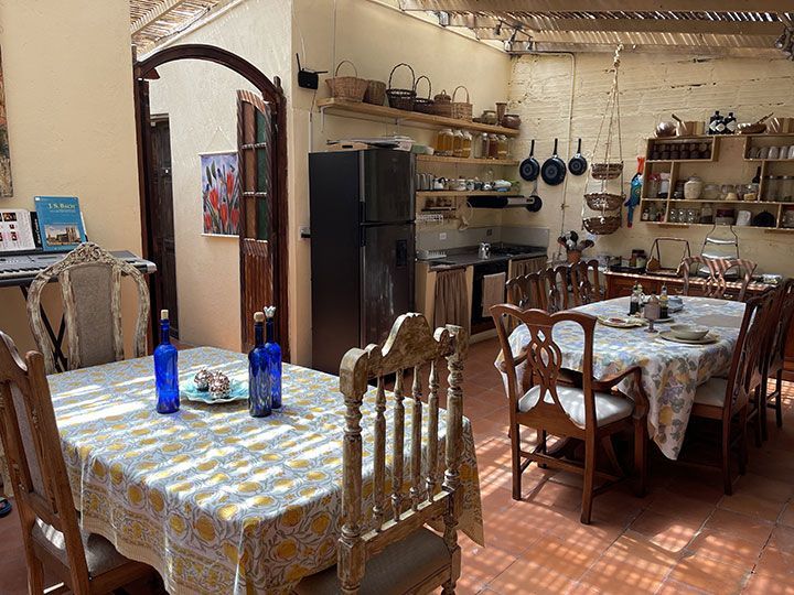Un comedor con una mesa y sillas y una cocina al fondo.