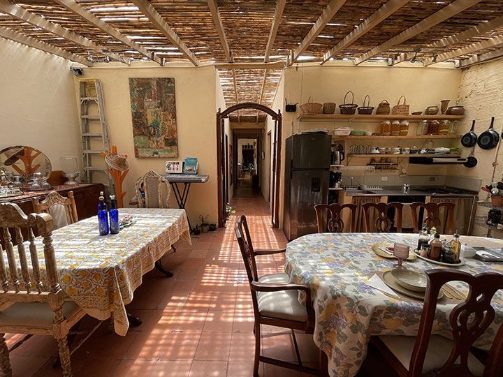 Un comedor con mesa y sillas y un refrigerador.