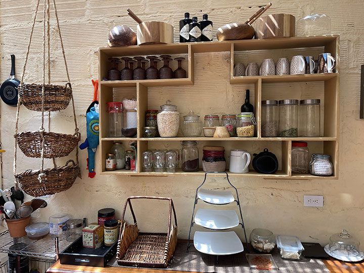 Una cocina con muchos estantes llenos de comida y utensilios.