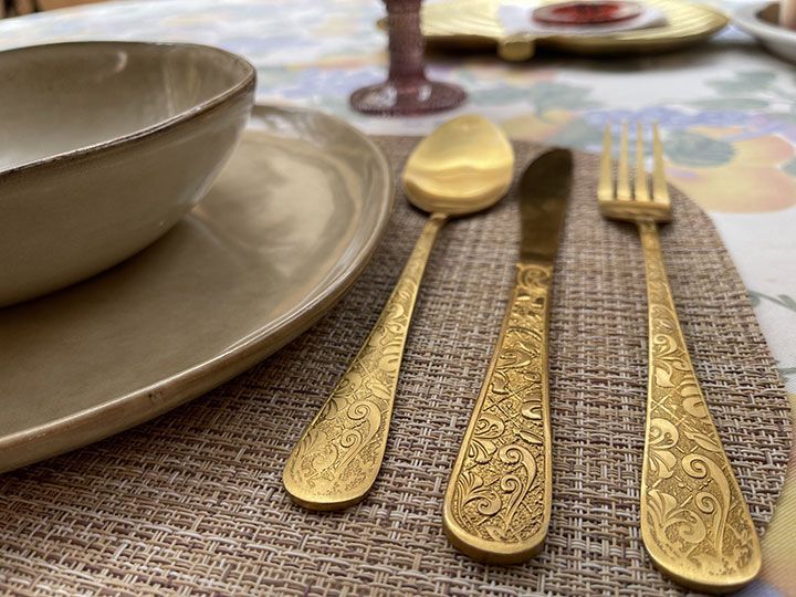 Una mesa con platos, utensilios y un cuenco sobre ella.