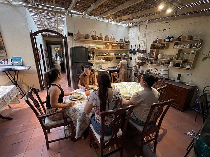 Un grupo de personas están sentadas alrededor de una mesa en una cocina.