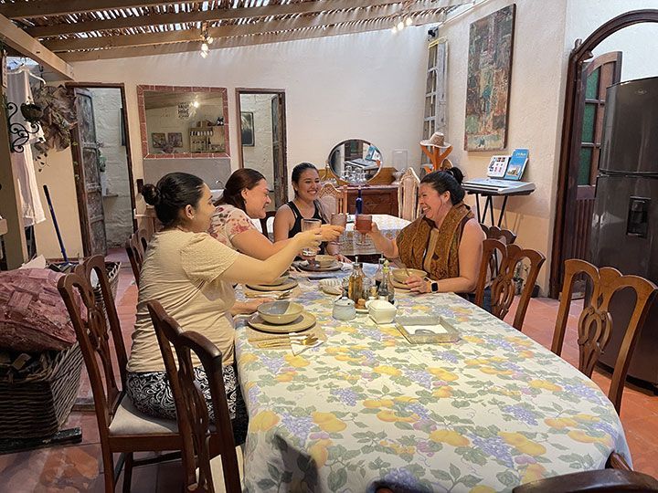 Un grupo de mujeres está sentada en una mesa bebiendo vino.