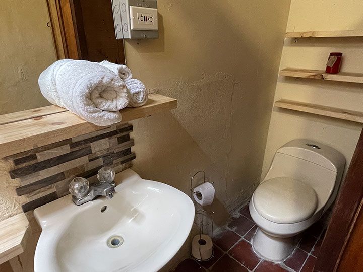 Un baño con inodoro, lavabo y espejo.