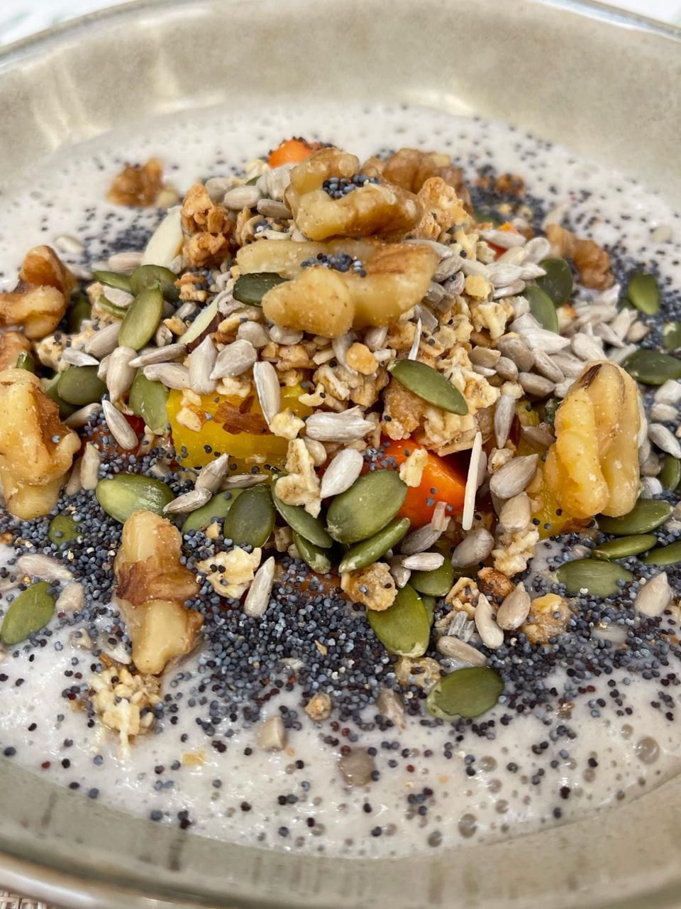 Un primer plano de un recipiente con comida, nueces y semillas.