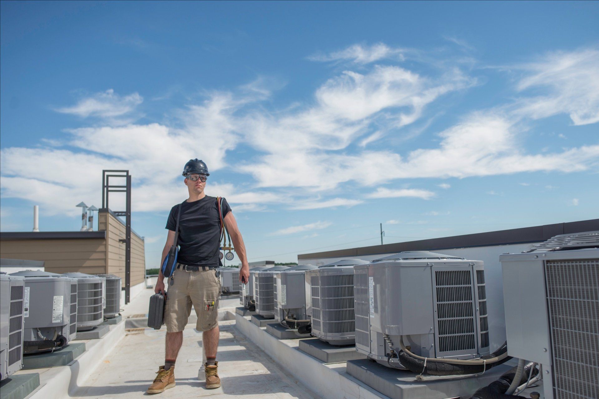Technician on top of building with A/C unites