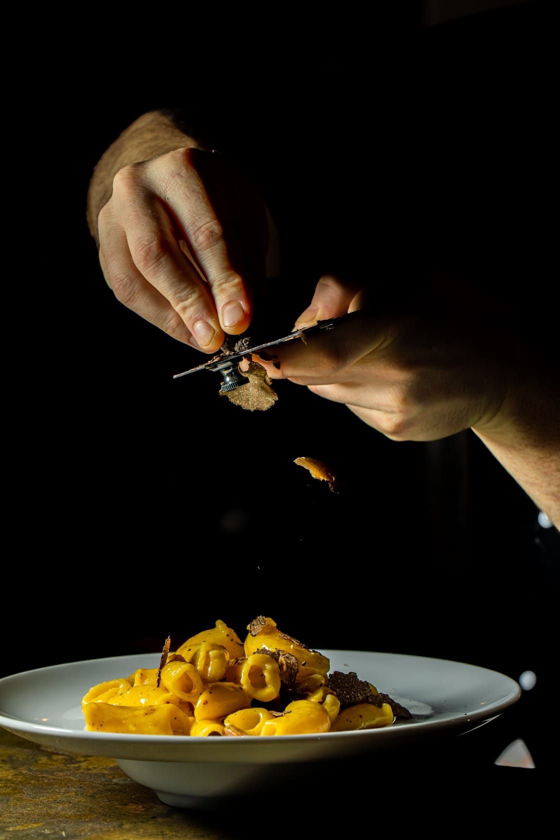 Una persona sta decorando un piatto di pasta con una forchetta.