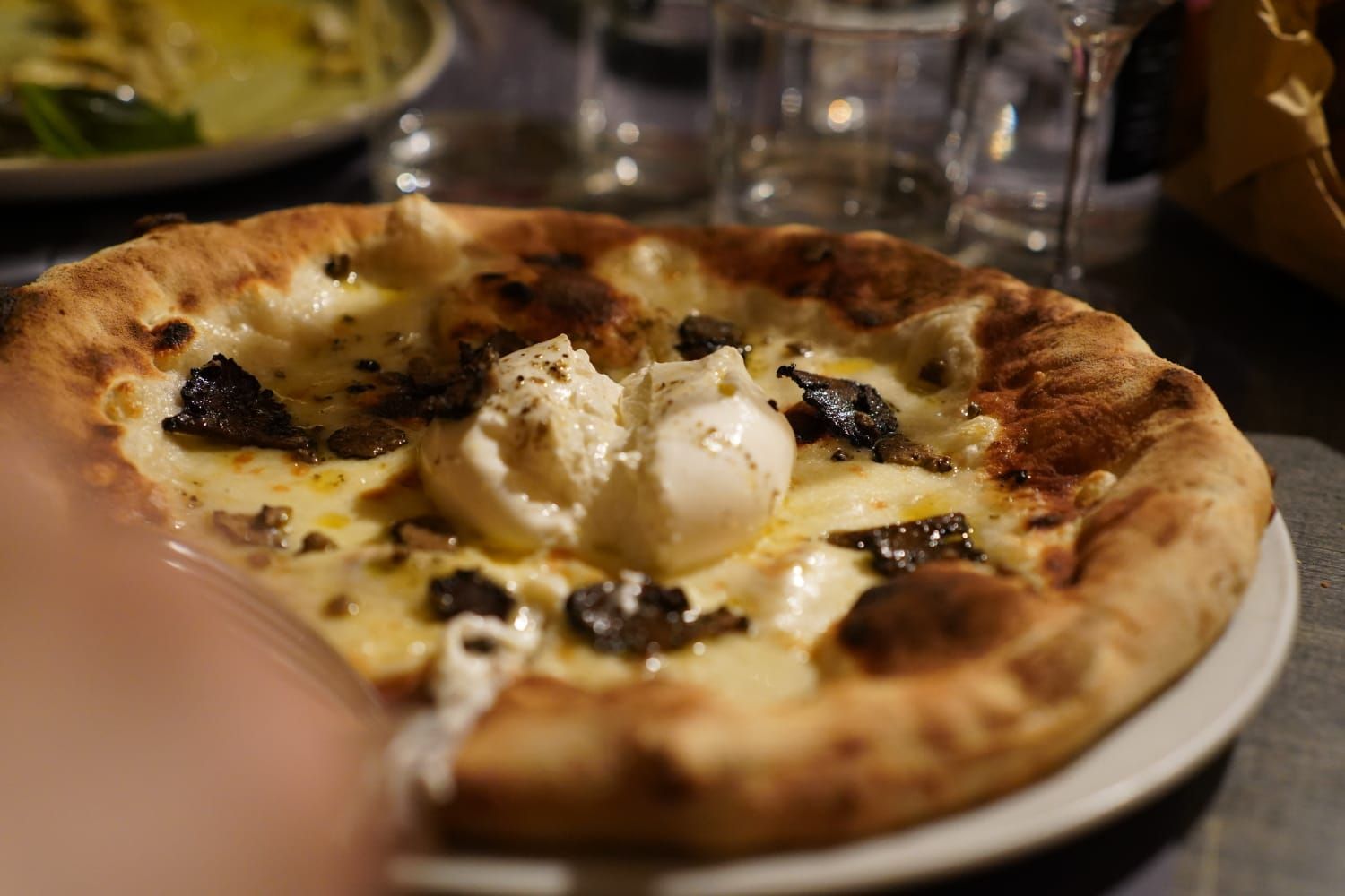 Un primo piano di una pizza su un piatto su un tavolo.