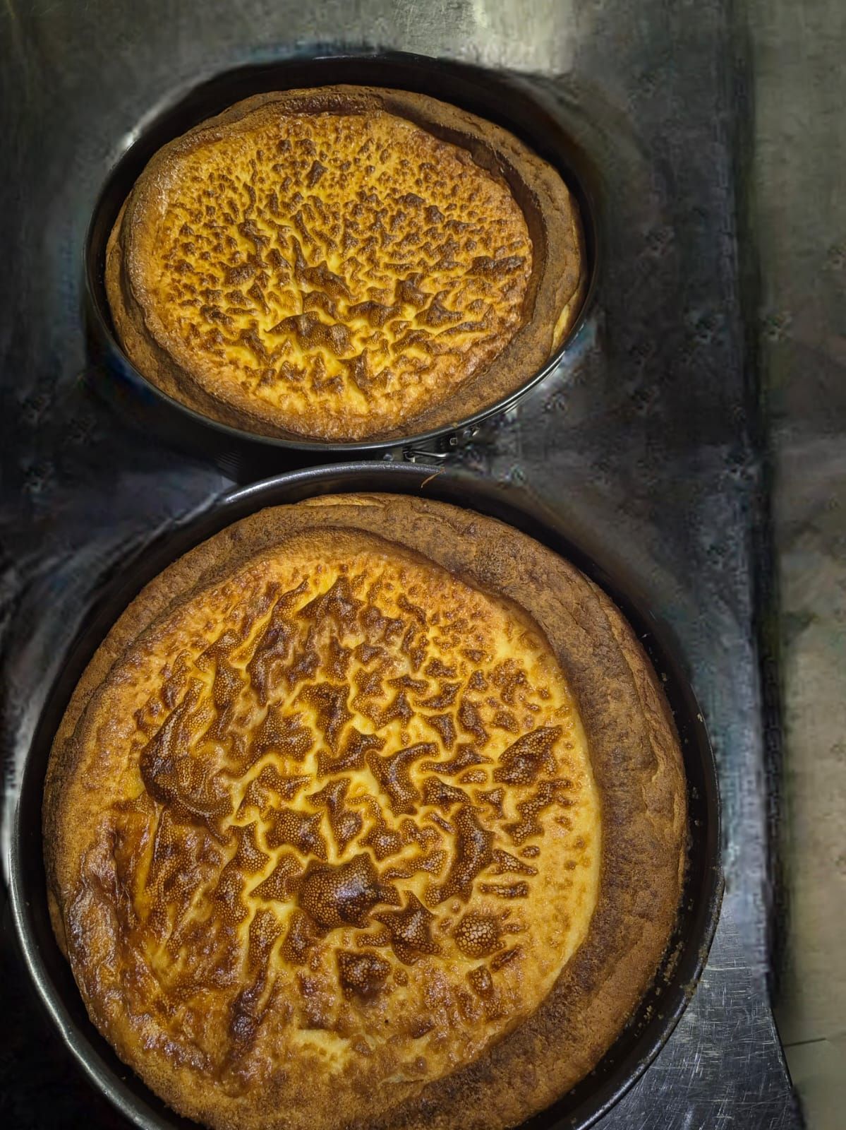 Su un bancone sono appoggiate due pizze, una sopra l'altra.