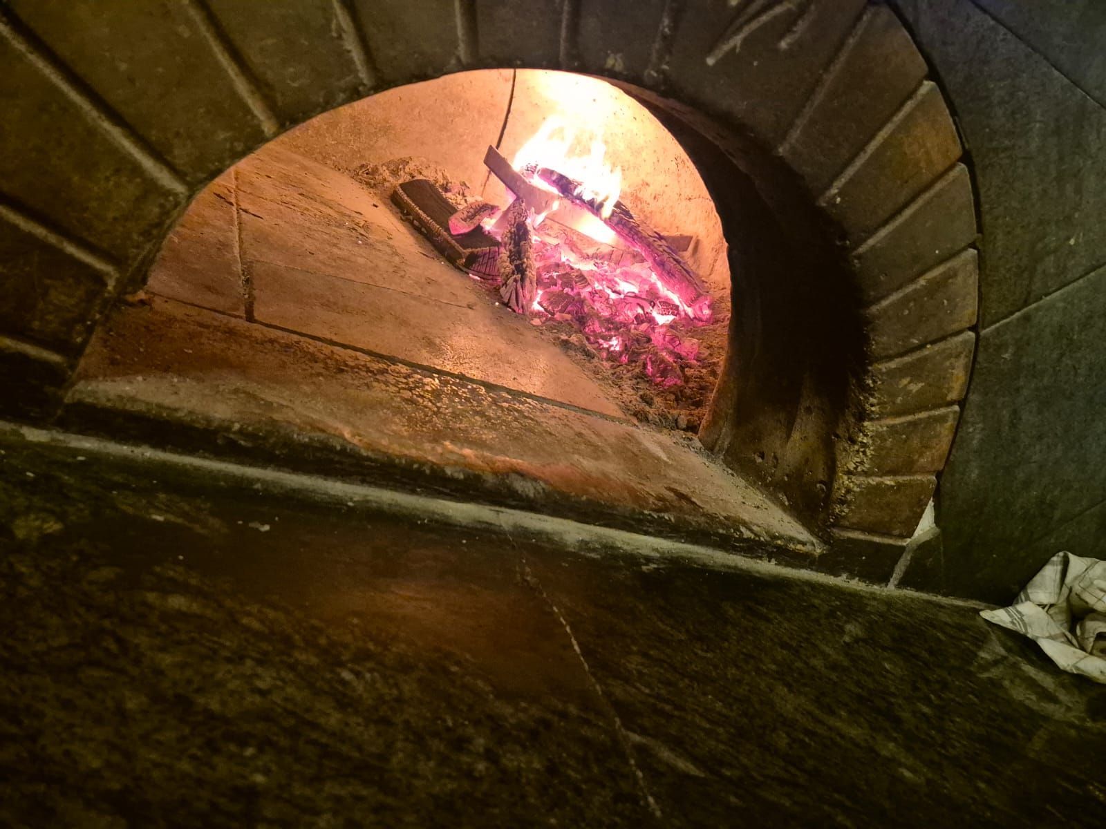 Un forno di mattoni da cui esce il fuoco.