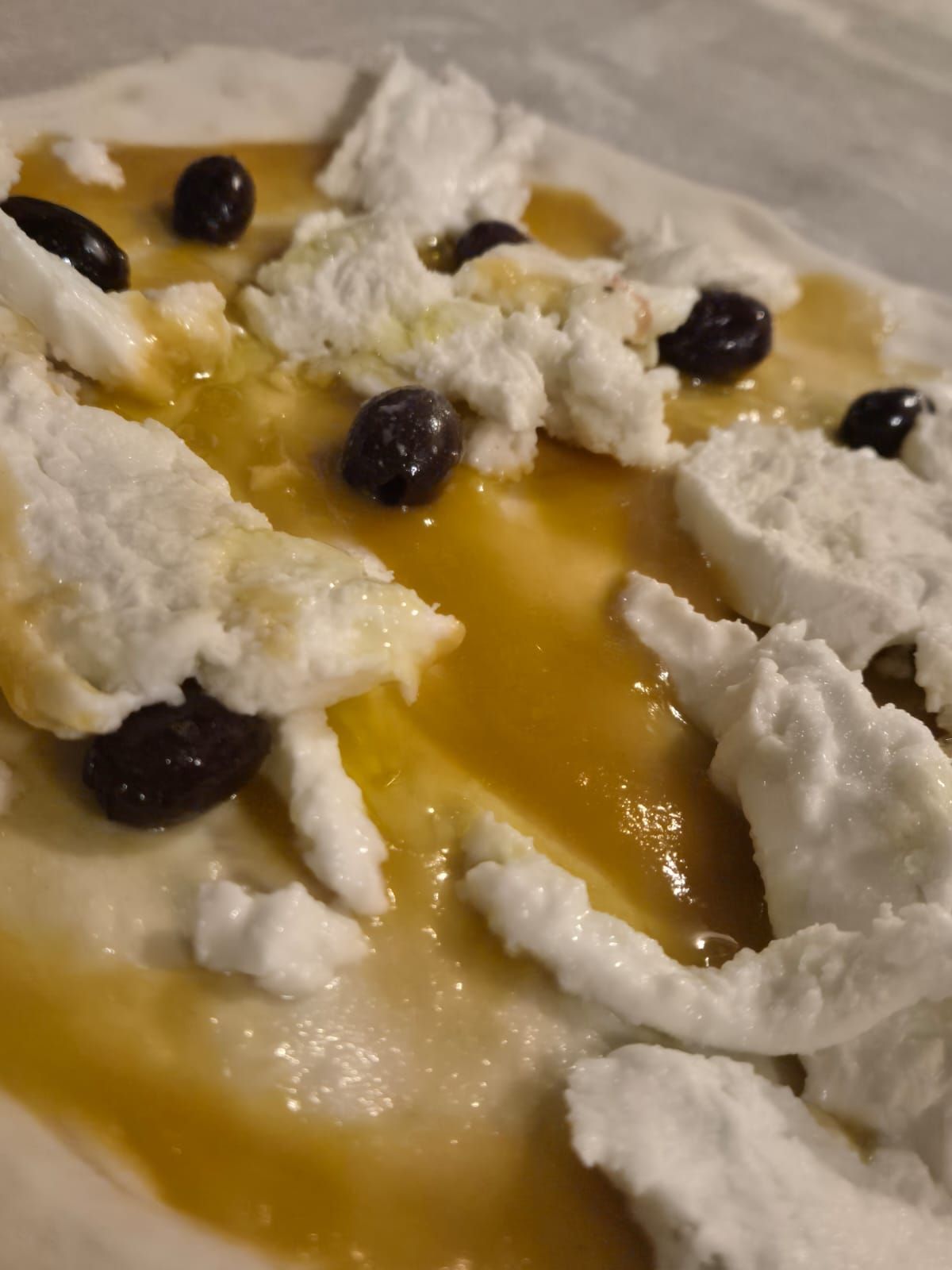 Un primo piano di una pizza con olive e panna montata