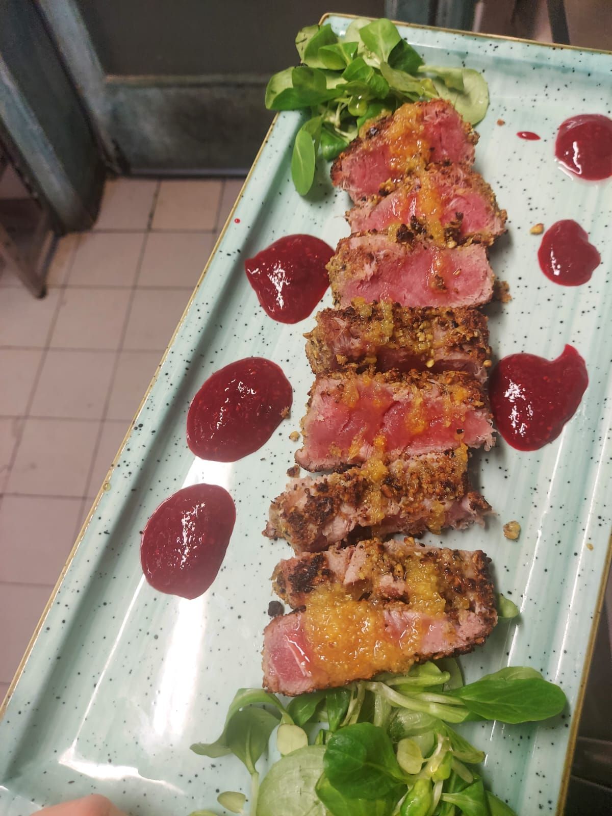 Un piatto di cibo con sopra carne e salsa