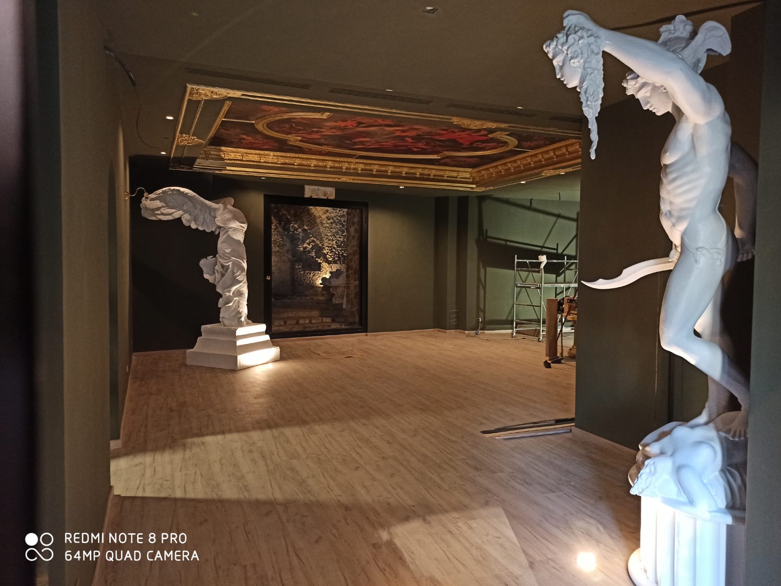 Interno del museo con statue classiche, dipinti e soffitto decorato.