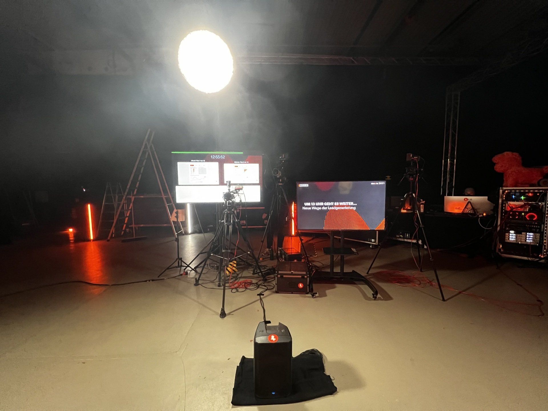 Ein dunkler Raum mit vielen Lichtern und einem Fernseher auf einem Ständer.