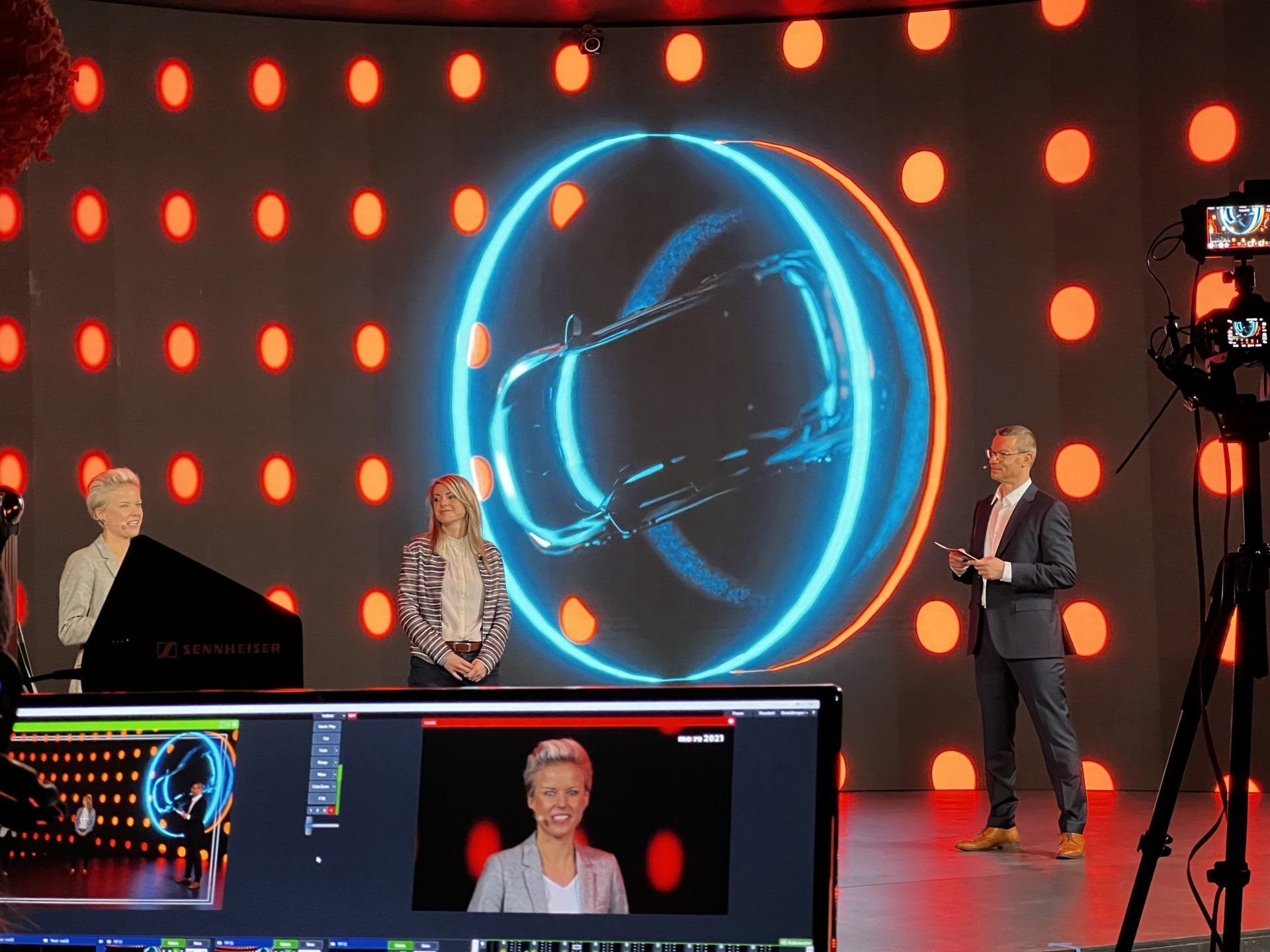 Eine Gruppe von Menschen steht vor einem großen Bildschirm.