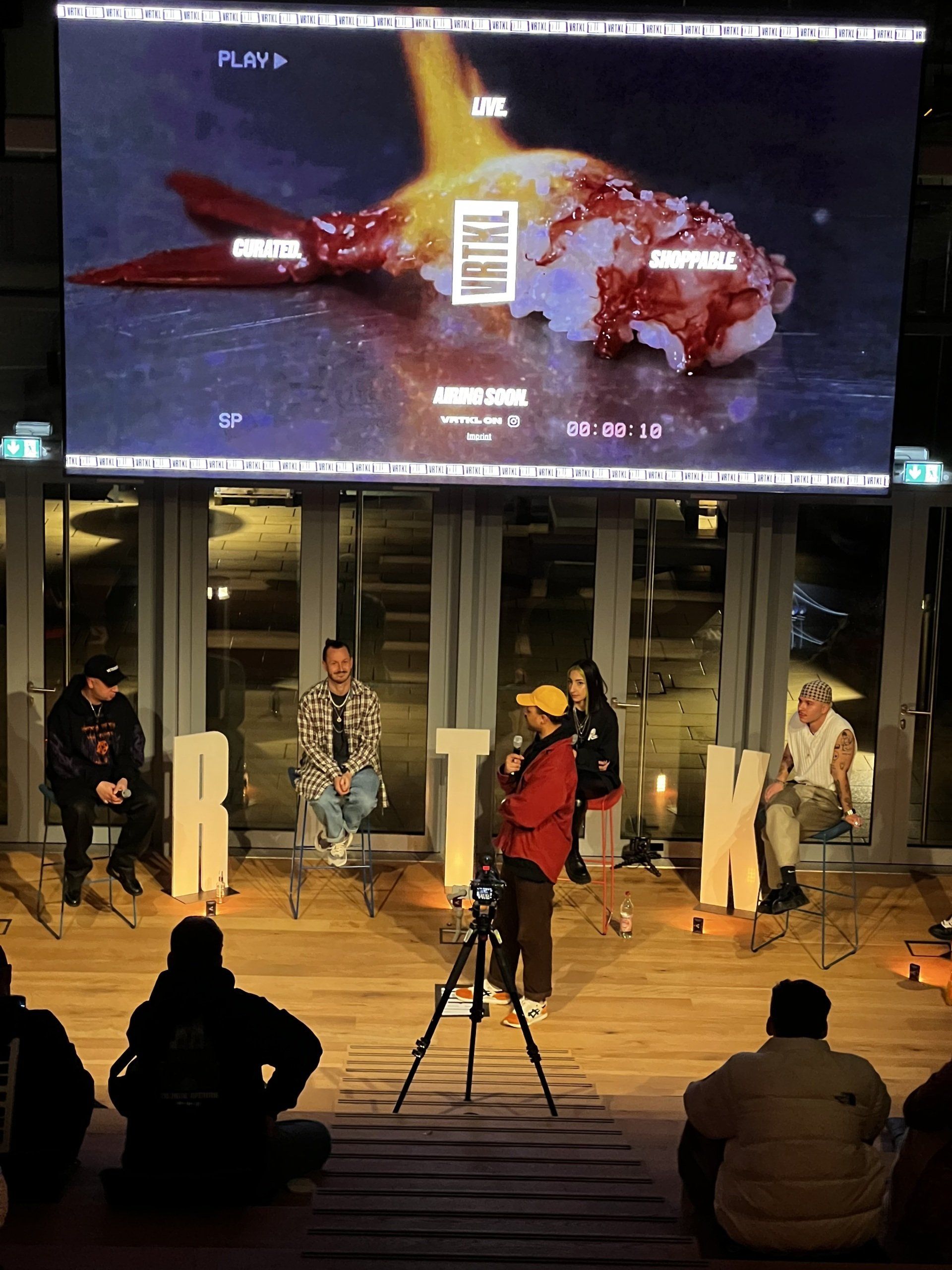 Eine Gruppe von Menschen sitzt vor einem großen Bildschirm